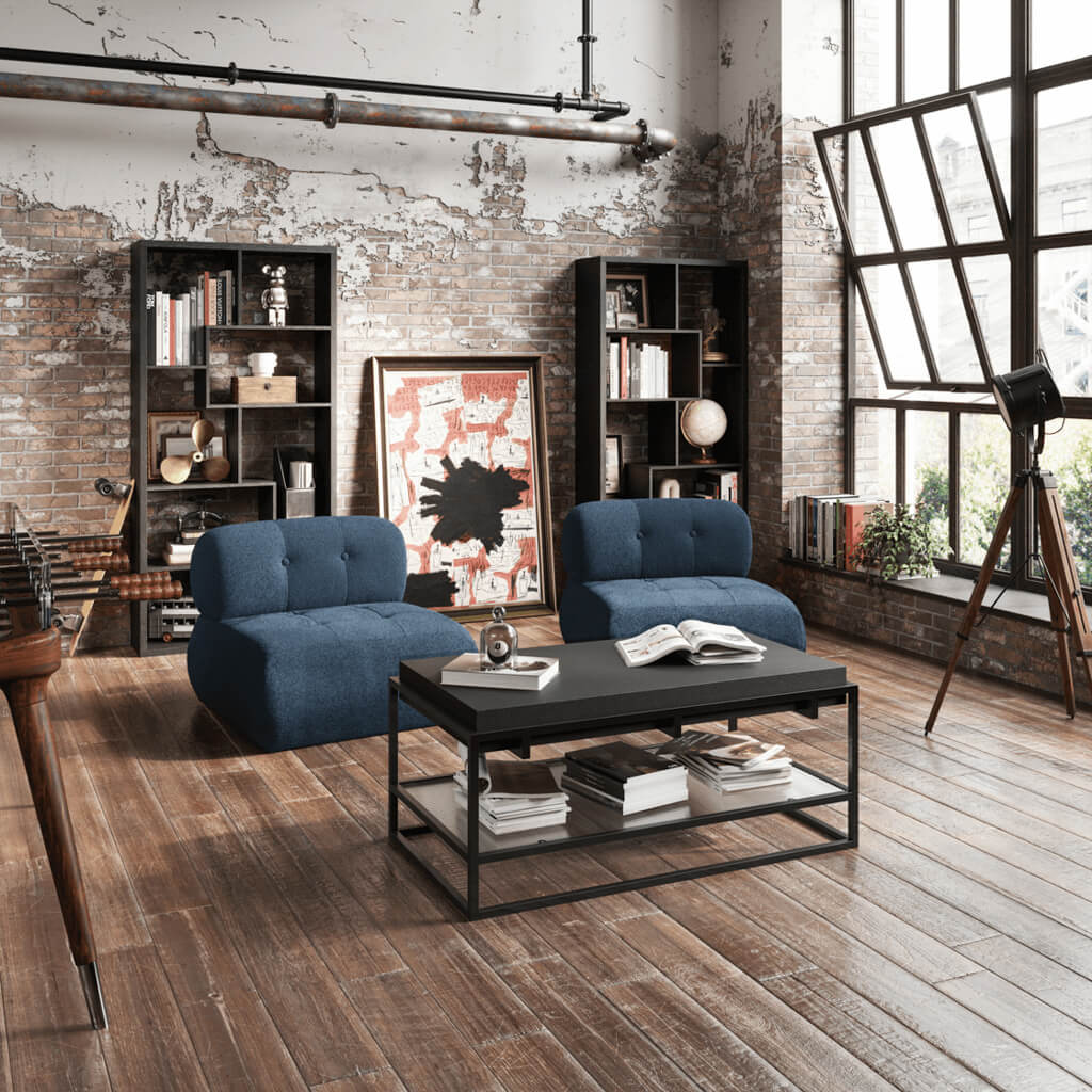 Modern living room with blue armchairs, a coffee table, and bookshelves.