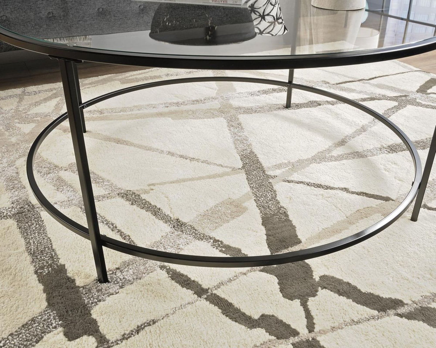 Round coffee table with glass top and black metal frame